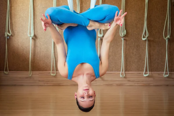 Retrato de uma bela jovem envolvida em ioga anti-gravidade em telas em uma pose de lótus. ioga na rede. O conceito de aero-ioga e o desenvolvimento de flexibilidade e alongamento — Fotografia de Stock