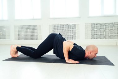 Adam stüdyoda yoga yapıyor. Yoga sınıfında sabah kuşları