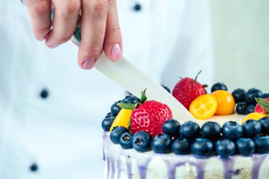 İştah açıcı ve masada beyaz bir arka planda çilekli düğün pastası. Yukarıdan bak. Şekerleme, pasta, yemek. düğün ve doğum günü pastası çilekli, yabanmersinli, dutlu .
