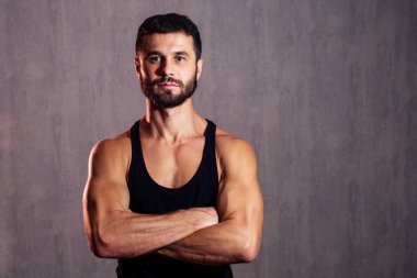 Siyah tişörtlü, esmer, kaslı, sağlıklı bir adam. Sağlıklı vücut ve cinsellik kavramı