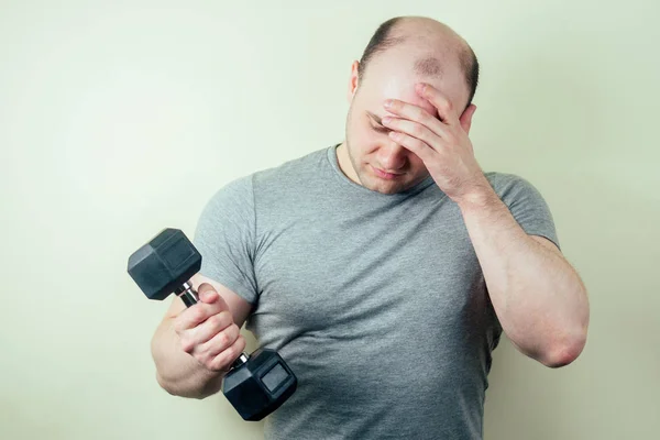 Retrato de un guapo boxeador masculino calentándose en el gimnasio. Boxeador y mancuerna amarilla en la mano. el hombre golpea . —  Fotos de Stock