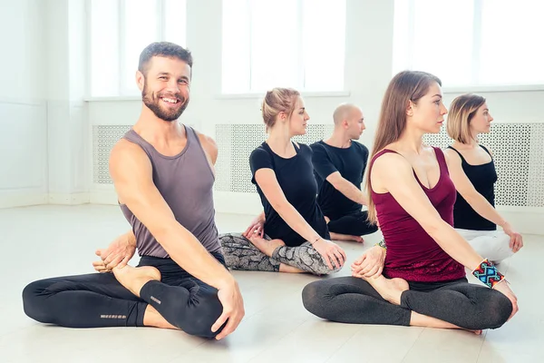 a happy group of people from men and women practicing yoga in the studio. groups of meditation and communication yoga class. the concept of group meditation and teamwork. the concept of anti-stress