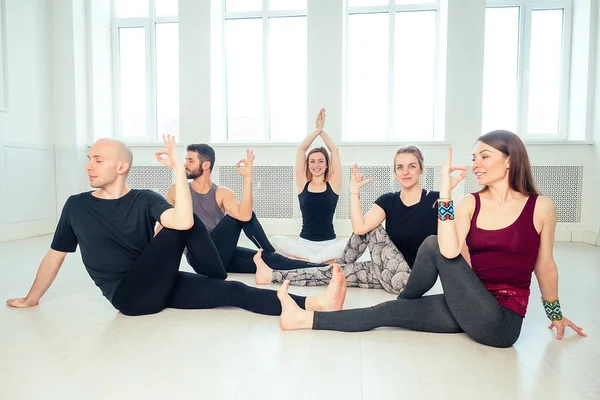 a happy group of people from men and women practicing yoga in the studio. groups of meditation and communication yoga class. the concept of group meditation and teamwork. the concept of anti-stress