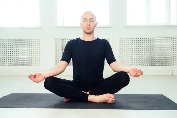 Чоловік практикує йогу в студії. ранкові асани в класі йоги — стокове фото