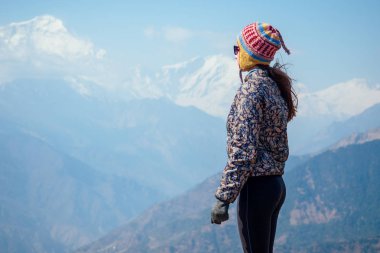 Dağlarda yürüyüş yaparken gülümseyen güzel ve aktif bir kadın. Dağlarda aktif eğlence ve turizm kavramı. Nepal Himalayaları 'nda yürüyüş