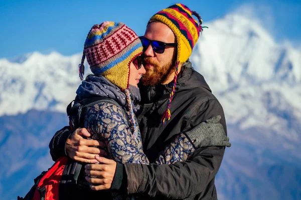 A beautiful and active woman and a man are hugging against the background of the mountains. the concept of active recreation and tourism in the mountains. couple in love trekking in Nepal Himalayas