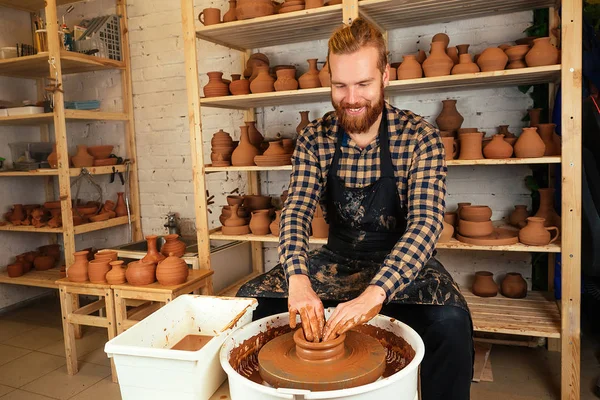 potter professional happy man working with brown clay in workshop . Stock  Photo by yurakrasil