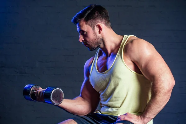 Joven y hermoso deportista atleta culturista hombre haciendo ejercicios para los músculos de las manos de pesas en el gimnasio — Foto de Stock