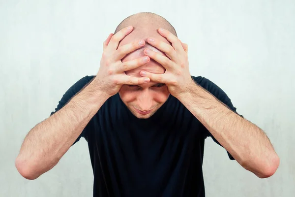 Un joven calvo y calvo grita y grita sosteniendo su cabeza. el concepto de la calvicie pérdida de cabello en los hombres —  Fotos de Stock