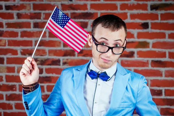 a man in a stylish suit is holding a flag of America in his hand. concept of celebrating the Independence Day on July 4