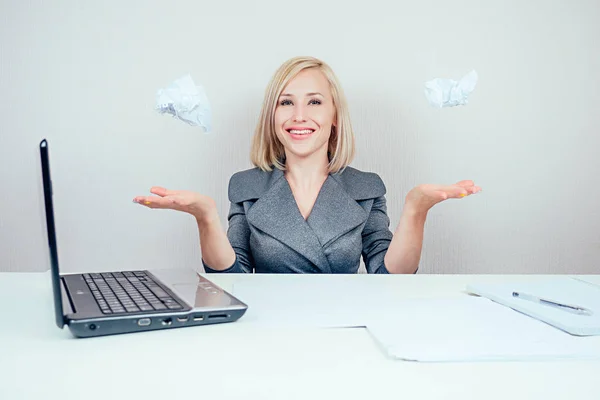 attractive smart blonde multitasking woman business lady in stylish business suit throws lumps of paper draft and having fun in office . business concept and deadline