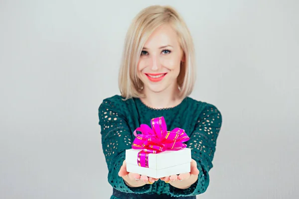 Attraktiv blond kvinna i grön klänning ger ljusa lådor med gåvor. semesterkoncept — Stockfoto