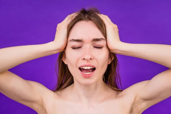 young teen girl acne pimple upset on purple background in studio . concept of puberty and clean skin