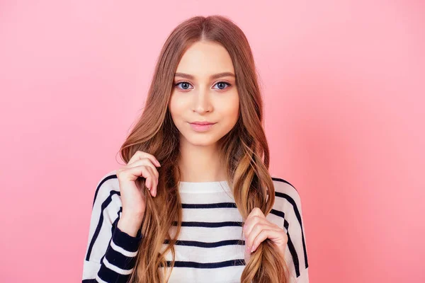Porträtt av en ung och attraktiv tonåring långhårig kvinna snygg modell i en randig tröja i studio på en rosa bakgrund. begreppet hälsosamt, starkt och tjockt hår — Stockfoto