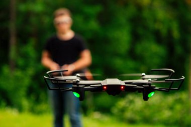 adam ve onun drone, yeşil bir arka plan üzerinde bir ormanda quadrocopter