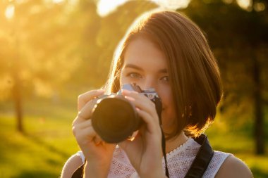 Parkta fotoğraf çeken profesyonel bir kadın fotoğrafçının portresi. Şehirde fotoğraf çekimi var.