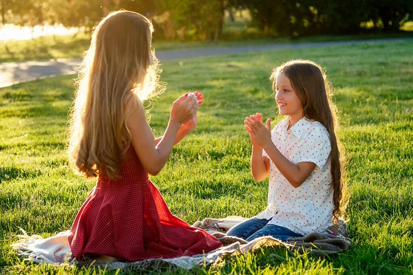 Bela e jovem mulher de cabelos longos brincando com sua filha em um dia de verão no parque — Fotografia de Stock