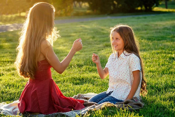 Mooie en jonge langharige vrouw spelen met haar dochter in een zomerse dag in het park. gelukkig moederschap en een prachtig kinderconcept — Stockfoto