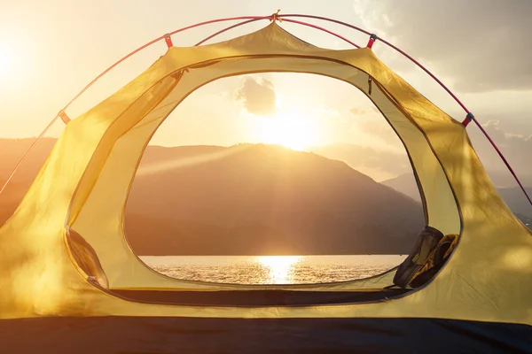 Álló sátor gyönyörű kilátással a hegyekre egy tó hajnalban — Stock Fotó