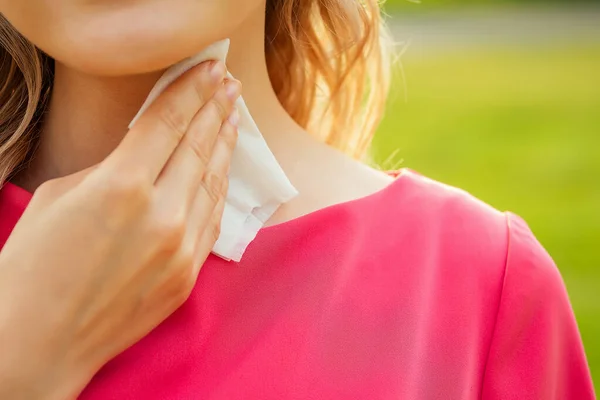 Parte del cuerpo de una mujer joven en un parque de ropa rosa. chica usando mojado toallitas el sudor en el cuello — Foto de Stock