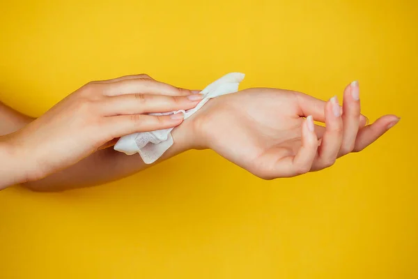 Guardanapo branco molhado na mão em um fundo amarelo — Fotografia de Stock