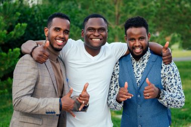 Üç siyahi adamdan oluşan bir grup yaz parkındaki bir toplantıya uyuyor. Afro-Amerikalı arkadaşlar İspanyol iş adamı dışarıda takım çalışması yapıyor.