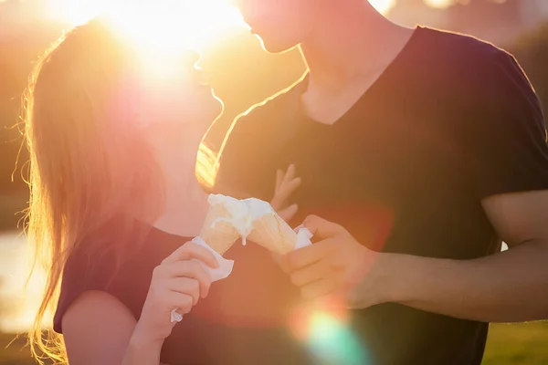 Boldog kaliforniai szerelmesek a nyári parkban. Gyönyörű nő és jóképű férfi jégkrémet eszik egy gofrisütő tölcsérben naplementekor a parton. hűvös fénykép fotózás fotózás fiatal család — Stock Fotó