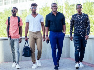 Dört yakışıklı Afrikalı işadamından oluşan bir grup. Amerikalı adam parkta şık bir şekilde yürüyor.