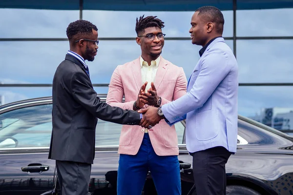 Um grupo de três amigos de negócios afro-americanos elegantes empresários de moda ternos de negócios reunião handshaking em um verão ao ar livre. conceito de bom negócio bem sucedido — Fotografia de Stock