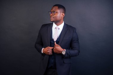 Yakışıklı siyah başarılı ve siyah takım elbiseli zengin Amerikan süper modeli. Stüdyo moda çekimi siyah arkaplanda izole edildi.