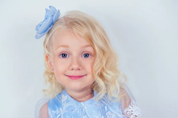 Portrait of a lovely little girl curly blonde hairstyle perfect skin and blue big eyes — Stock Photo, Image