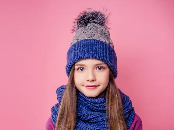 Bonito menina em quente tricotado chapéu colorido no fundo rosa em studio.Children roupas de inverno — Fotografia de Stock