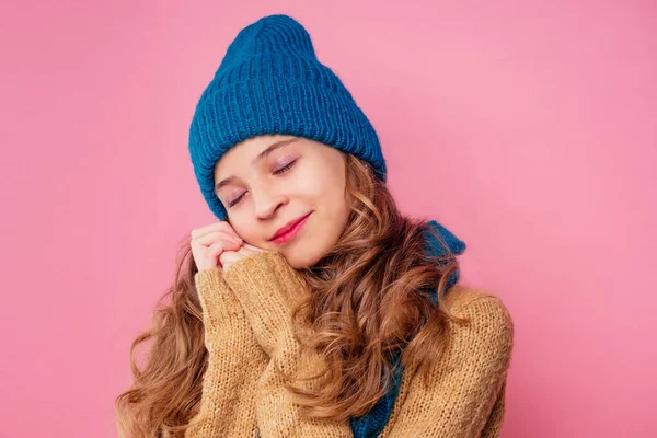 아름다운 겨울작은 소녀의 따뜻 한 색상의 모자와 스카프 꿈에 스튜디오에서 크리스마스 밤 핑크 배경에 선물을 생각 — 스톡 사진