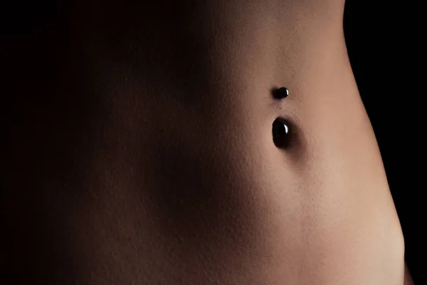 Perfect vrouwelijk lichaam navel piercing erotische fotoshoot op zwarte achtergrond in studio shot — Stockfoto