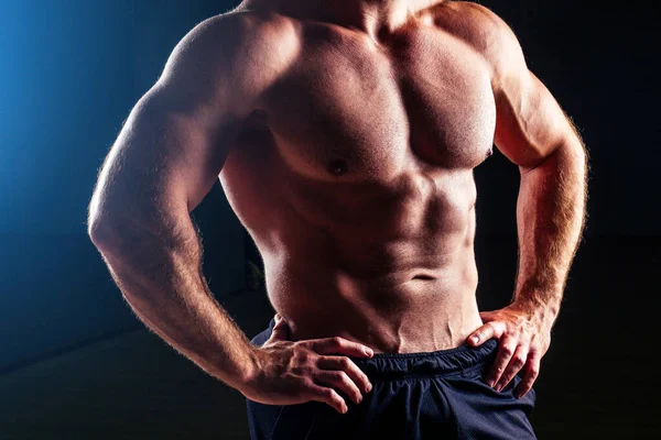 Muskularne tułów sexy młody fitness mężczyzna kulturysta model moc atletyczny człowiek antyczny posąg z idealne mięśnie sześciopak abs i nagie piersi pozowanie na ciemnym tle — Zdjęcie stockowe