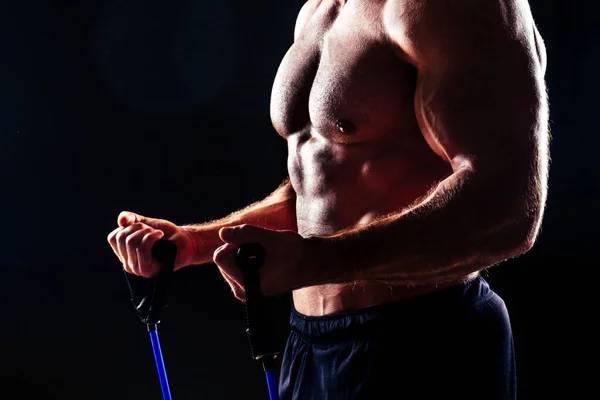 Muskulöser Fitness Mann antike perfekte Muskeln Sixpack Bauchmuskeln und nackter Brust Bodybuilder Modell beim Training mit Stretching Gummi Stretching Band auf schwarzem Hintergrund im Studio Training Workout Gym — Stockfoto