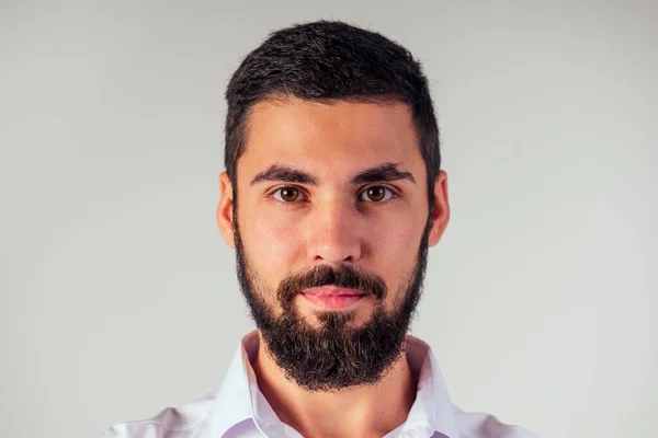 portrait of black bearded handsome man with brown eyes in the studio on a white background