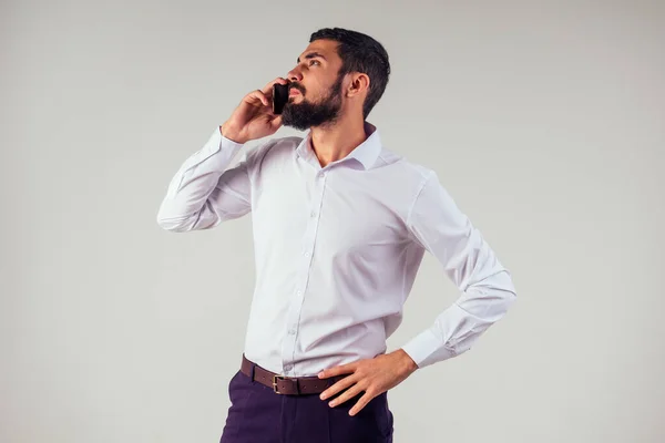 Empresario barbero propietario de la tienda utilizando el teléfono móvil. Joven caucásico barbudo hombre sosteniendo teléfono inteligente para el trabajo de negocios . — Foto de Stock