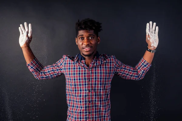 Drunk African American Afro businessman sloppy man with dreadlocks hands up soiled in white powder dust chemical drug police arrest Cuba on a black background in the studio.surrenders to the police