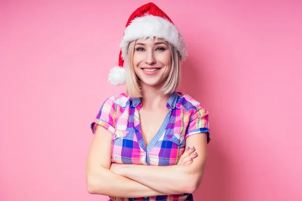 Porträtt av ung Beautyful blond förbluffad kvinna med julklapp på röd bakgrund. dam i rutig skjorta och Santa claus hålla en påse full av presenter på en rosa bakgrund i studion — Stockfoto