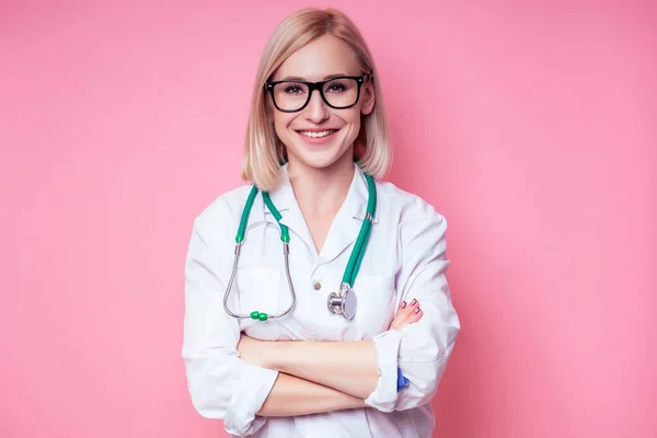 Kobieta młoda i piękna blondynka weterynarz lekarz za pomocą stetoskopu w białym płaszczu medycznym na różowym tle w studio — Zdjęcie stockowe