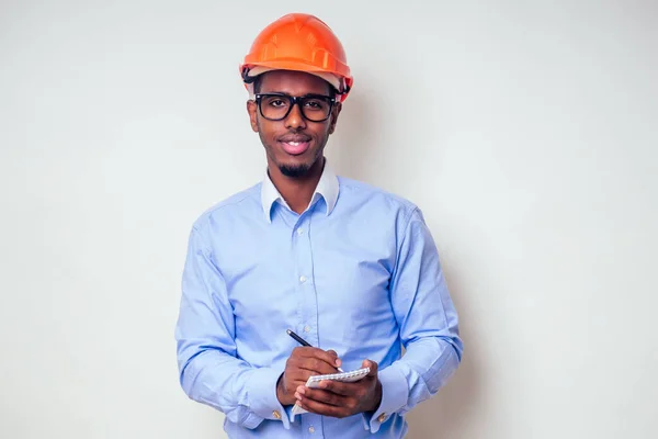 architect designer black man African American holding paper drawing template.happy african builder painting house,businessman wears a helmet hard hat.young guy is painting sketch construction plan