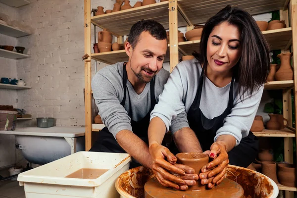 幸福的家庭在一个创造性的联合度假。浪漫的情侣在爱一起工作的陶子轮和雕刻粘土锅, 一个胡须男子和一个年轻女子在工艺工作室车间塑造花瓶. — 图库照片