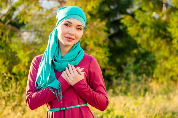 Islamische schöne Frau in einem muslimischen jungfräulichen Kleid steht auf einem Sommer Park Straße Hintergrund Wald Herbst Bäume — Stockfoto