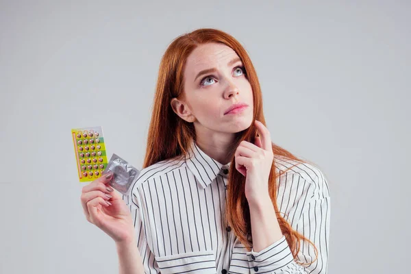 Bild av ung rödhårig gå förlorad i tanken affärskvinna i randig skjorta med ett paket piller tänkande vit bakgrund studio — Stockfoto