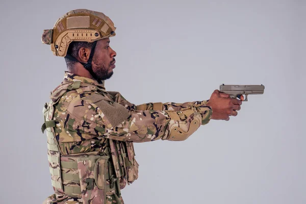 Hombre americano en traje de camuflaje apuntando con una pistola de tiro de estudio — Foto de Stock