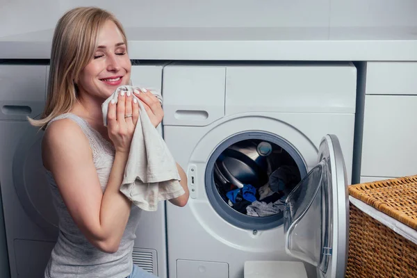 Glad blond kvinnlig tvätt kläder känna sig glad över mjuk fräsch tvätt doft tyg mjukgörare aromaterapi — Stockfoto