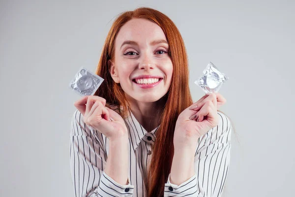 Imagen de la joven pelirroja perderse en el pensamiento mujer de negocios en camisa a rayas con paquete de condón y el nacimiento elegir pensamiento estudio de fondo blanco — Foto de Stock