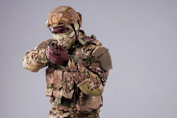 Amerikaanse man in camouflage pak mikken met een pistool studio schot — Stockfoto