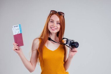 Kızıl saçlı mutlu kadın turist beyaz arka plan stüdyosunda yatılı geçiş kamerasıyla